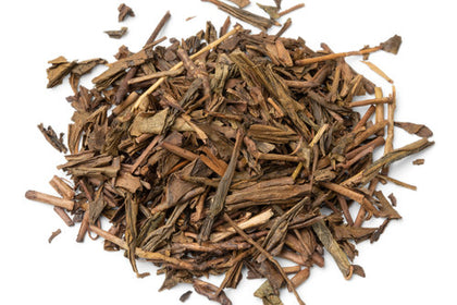 Feuilles de thé vert hojicha torréfié en vrac sur fond blanc