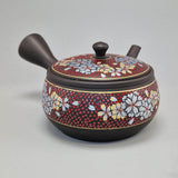 Théière Kyusu Kutani bordeaux, vue de face avec les fleurs de cerisier peintes et le bec à droite