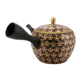 Théière Kyusu Kutani à fleurs de cerisier roses, jaunes et rouges, vue de côté avec la grande anse noire à gauche, sur fond blanc