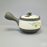 Théière Kyusu verte à décor de vigne et de raisins, vue de côté avec l'anse latérale à gauche